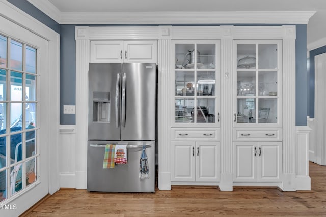 300 S Pine St, Benson, NC 27504 - kitchen with stainless steel fridge with ice dispenser, white cabinetry, light wood-type flooring, ornamental molding, and glass insert cabinets
