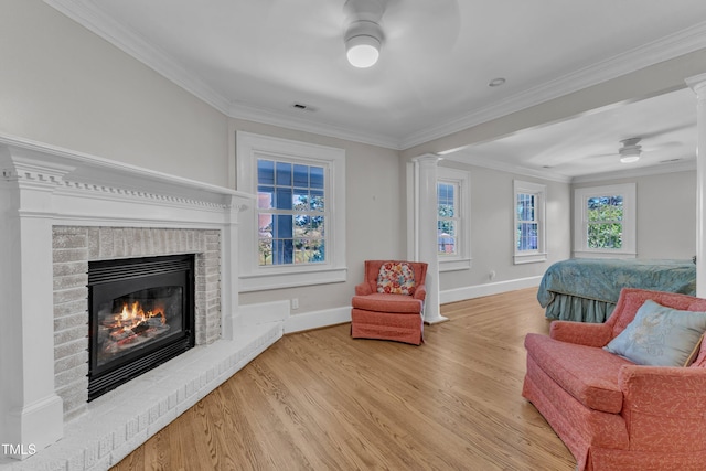 300 S Pine St, Benson, NC 27504 - sitting room with a ceiling fan, wood finished floors, a brick fireplace, crown molding, and decorative columns
