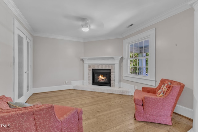 300 S Pine St, Benson, NC 27504 - living area featuring crown molding, wood finished floors, a brick fireplace, and a ceiling fan