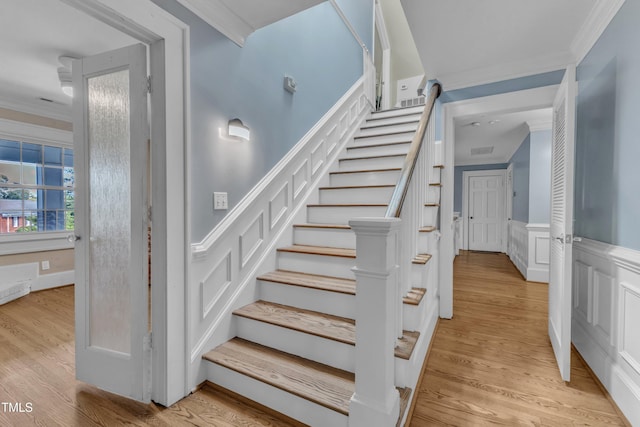 300 S Pine St, Benson, NC 27504 - stairway with crown molding, wood finished floors, wainscoting, and a decorative wall