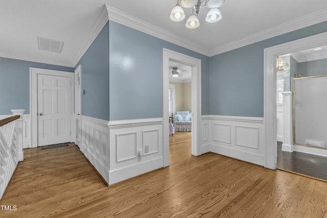 300 S Pine St, Benson, NC 27504 - corridor with wood finished floors, wainscoting, ornamental molding, a chandelier, and a decorative wall