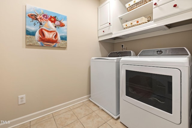 laundry area with baseboards, cabinet space, washing machine and dryer, and light tile patterned flooring