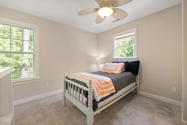 carpeted bedroom with visible vents, baseboards, and multiple windows