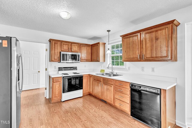 7109 Spanglers Spring Way, Raleigh, NC 27610 - kitchen featuring a textured ceiling, a sink, light countertops, light wood-style floors, and stainless steel appliances