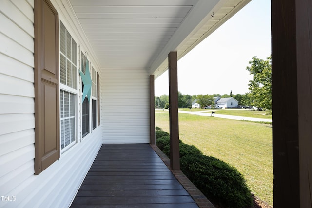 wooden deck featuring a lawn and covered porch