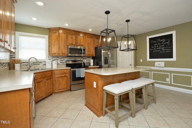 kitchen featuring backsplash, appliances with stainless steel finishes, brown cabinets, a sink, and light tile patterned floors