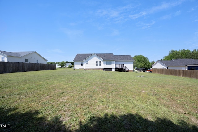 rear view of property featuring fence, a lawn, a deck, and crawl space