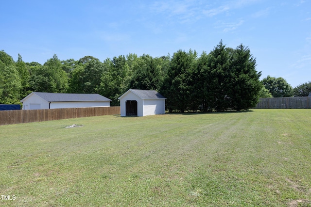 view of yard featuring fence, an outbuilding, and a storage unit