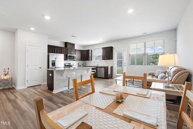 dining area featuring light wood-type flooring, plenty of natural light, recessed lighting, and baseboards