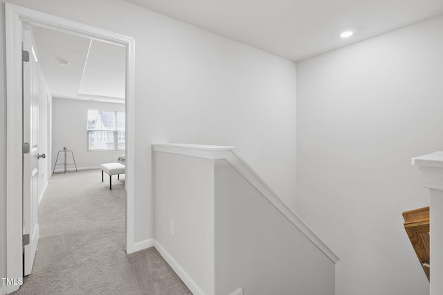 hallway with an upstairs landing, carpet floors, baseboards, and recessed lighting