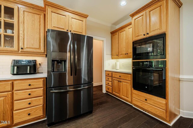 kitchen with light countertops, glass insert cabinets, black appliances, and tasteful backsplash