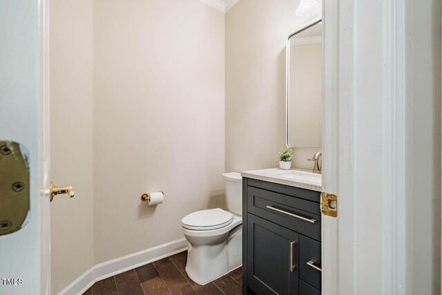 bathroom with vanity, baseboards, and toilet