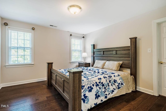 bedroom featuring visible vents, baseboards, and hardwood / wood-style floors