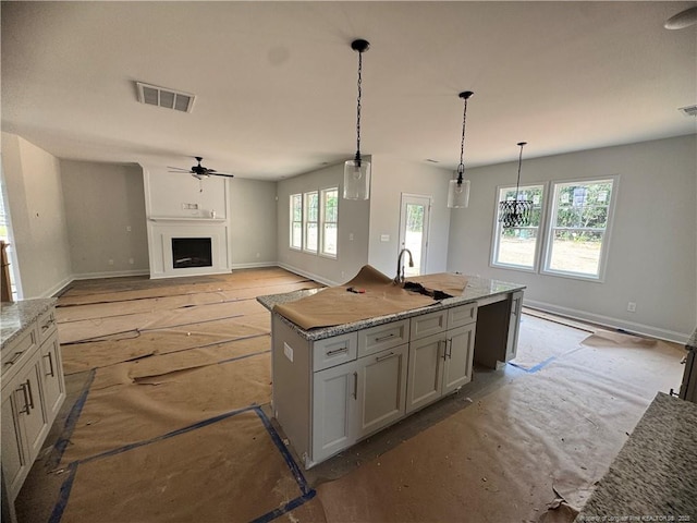 303 Hendrix B Rd, Raeford, NC 28376 - kitchen with a fireplace, a center island with sink, ceiling fan, and decorative light fixtures