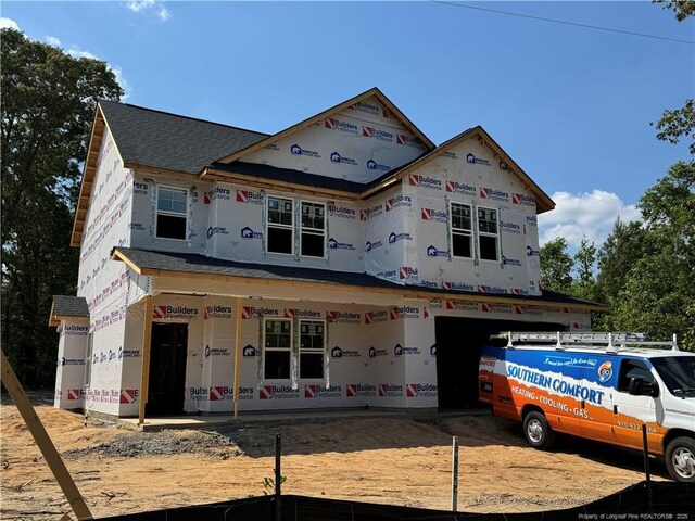 unfinished property featuring a porch and roof with shingles