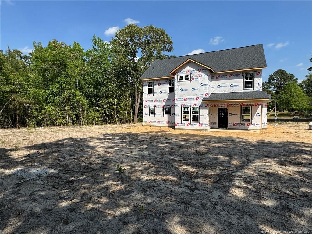 property in mid-construction with a shingled roof