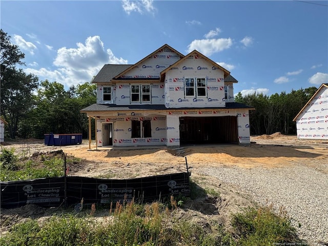 property under construction featuring a garage, dirt driveway, and a porch
