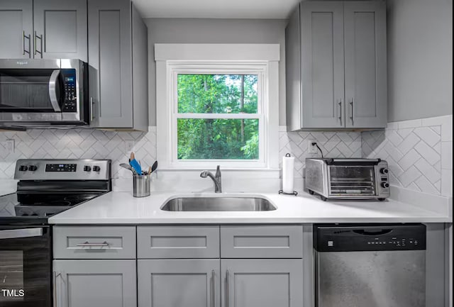 1402 Robinhood Rd, Durham, NC 27701 - kitchen featuring light countertops, appliances with stainless steel finishes, gray cabinets, and a sink
