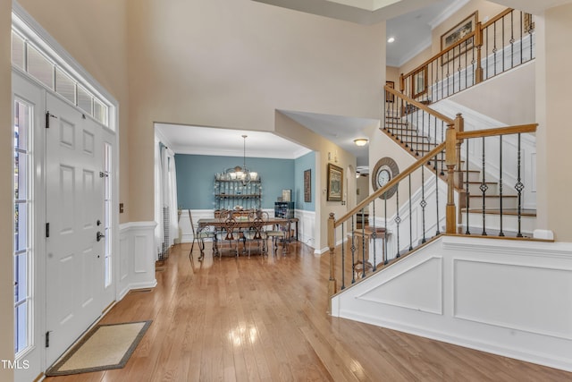 foyer featuring crown molding, stairs, a high ceiling, and hardwood / wood-style flooring