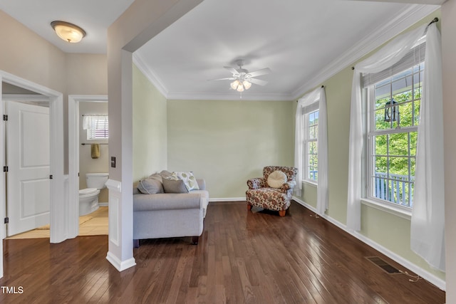 living area featuring baseboards, ornamental molding, ceiling fan, and hardwood / wood-style flooring