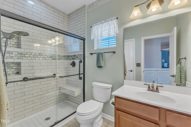 full bathroom with vanity, a shower stall, and toilet