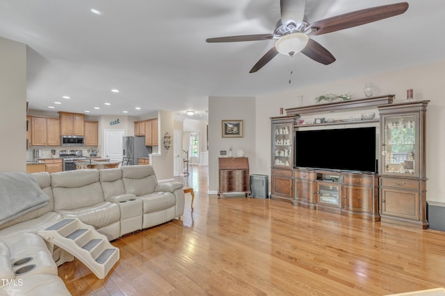 living area featuring recessed lighting, ceiling fan, baseboards, and light wood-style floors