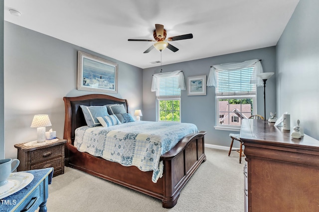 bedroom with light colored carpet, baseboards, ceiling fan, and visible vents