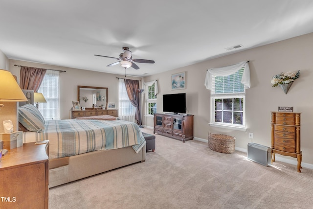 carpeted bedroom featuring visible vents, ceiling fan, and multiple windows