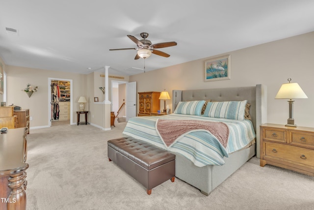 bedroom featuring visible vents, light colored carpet, baseboards, a closet, and a spacious closet