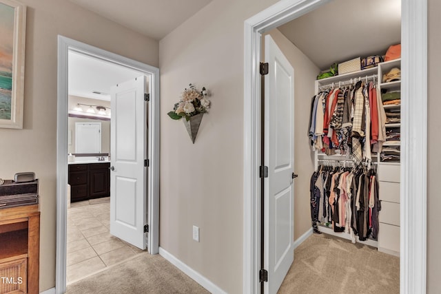 hallway with baseboards and light carpet