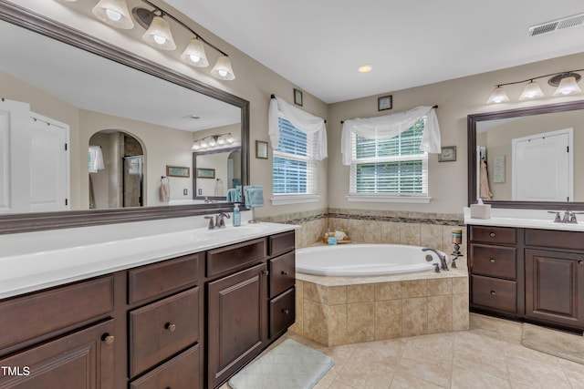 bathroom with a sink, tile patterned floors, two vanities, visible vents, and a garden tub