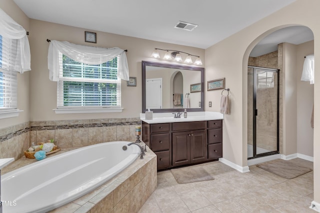 bathroom featuring visible vents, a stall shower, a bath, and a healthy amount of sunlight