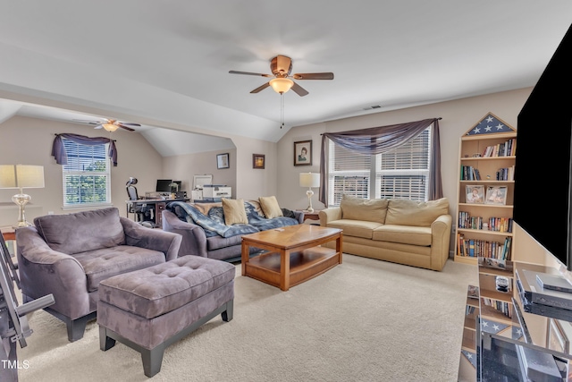 living area featuring vaulted ceiling, light carpet, a ceiling fan, and visible vents