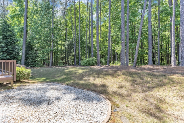 view of yard featuring a deck and a view of trees