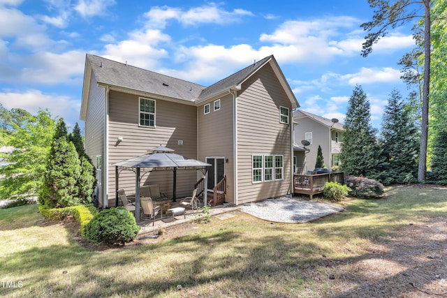 back of property with a patio, a wooden deck, a yard, and a gazebo