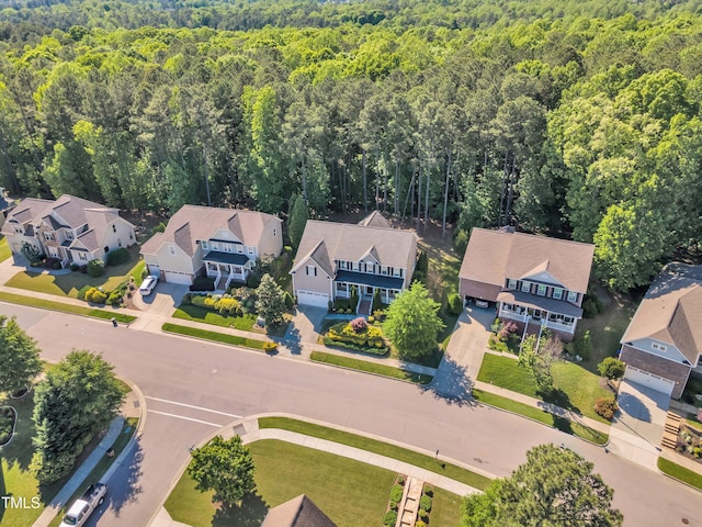 drone / aerial view with a residential view and a wooded view