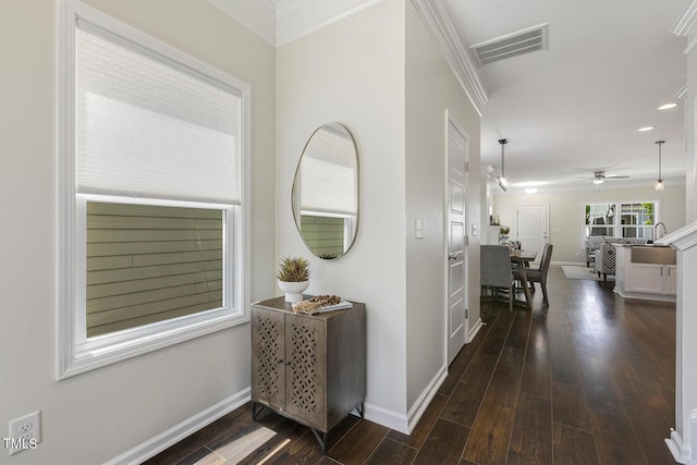 hallway with visible vents, crown molding, dark wood-style flooring, baseboards, and recessed lighting