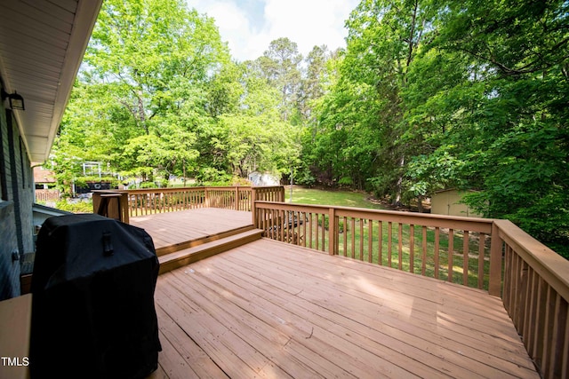 wooden terrace with a storage shed, an outbuilding, and a grill