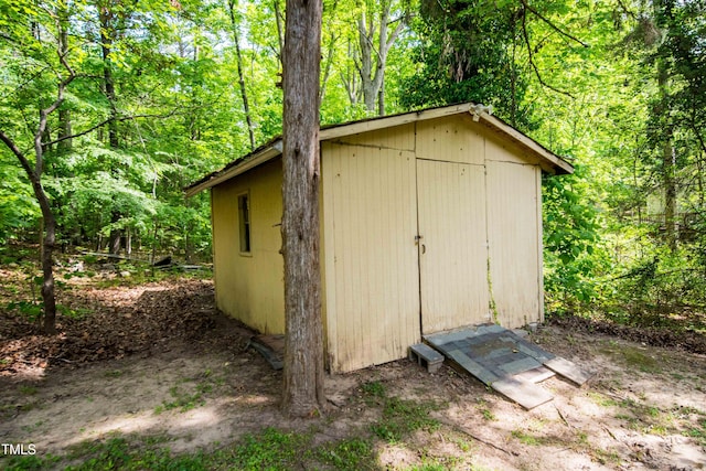 view of shed featuring a view of trees