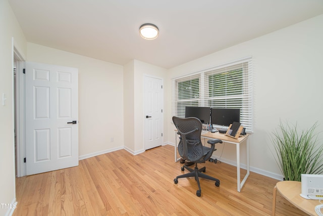 office space with baseboards and wood finished floors