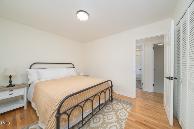 bedroom featuring baseboards, a closet, and light wood-type flooring