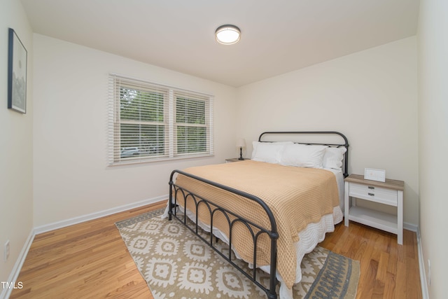 bedroom featuring baseboards and wood finished floors