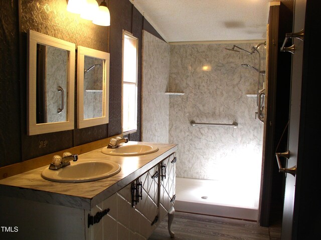 full bath with wood finished floors, a sink, walk in shower, and lofted ceiling