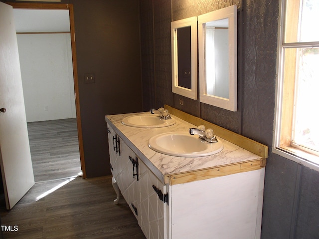 bathroom featuring double vanity, a sink, and wood finished floors