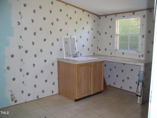 interior space with a sink, ornamental molding, and wallpapered walls