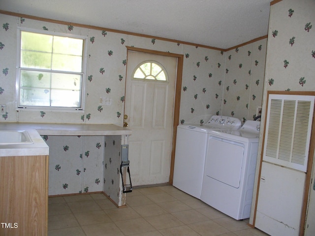 washroom with laundry area, crown molding, a sink, wallpapered walls, and washer and clothes dryer