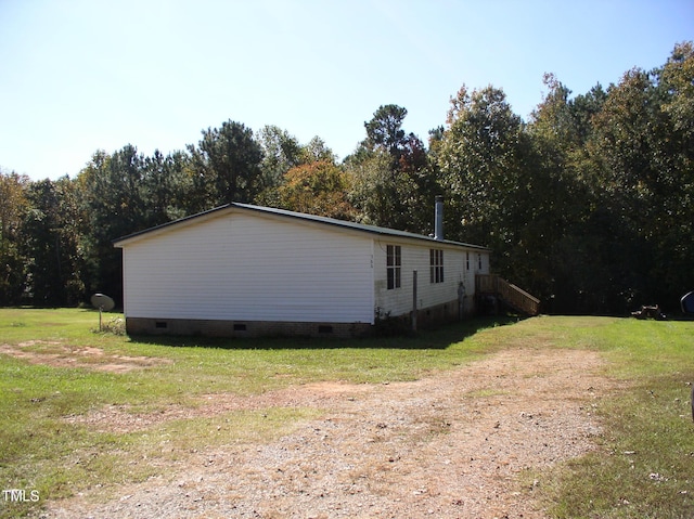 view of side of home with a lawn and crawl space