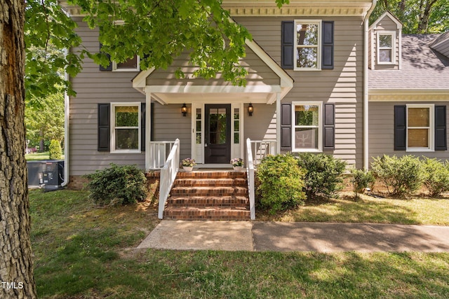 colonial home featuring cooling unit and a front lawn
