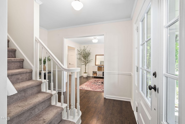 foyer entrance with baseboards, ornamental molding, dark wood-style flooring, and stairway