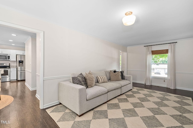 living area featuring baseboards, ornamental molding, and wood finished floors
